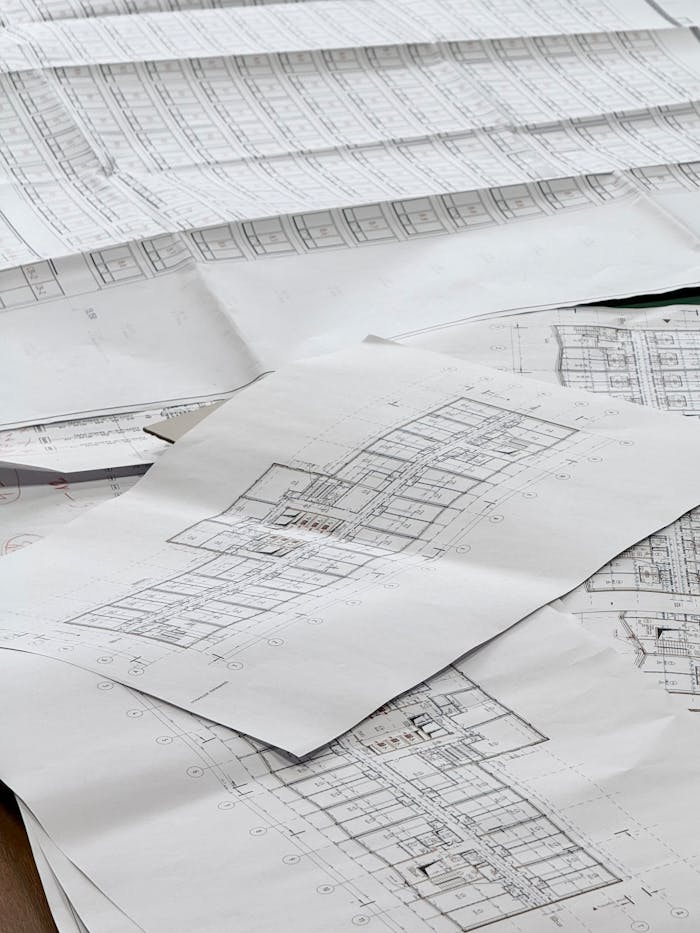 Close-up of detailed architectural blueprints spread out on a desk.